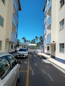 a car parked in a parking lot between two buildings at Apart - em frente á praia dos milionários- Ilhéus in Ilhéus