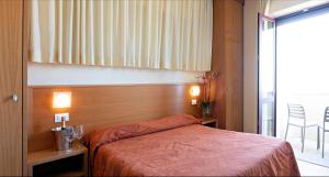 una camera con letto e testata in legno di Hotel Mirage a Viareggio