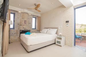 um quarto com uma cama e uma parede de tijolos em Evgeniko Villa em Kardamili