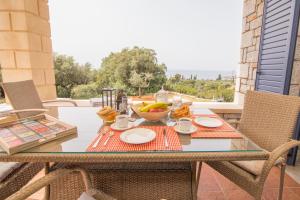 a table with a bowl of fruit on a balcony at Evgeniko Villa in Kardamyli