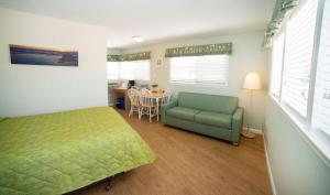 a bedroom with a bed and a couch and a table at Sea Gull Motel in Wildwood