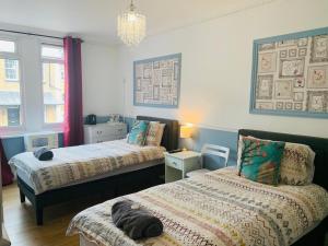 um quarto com 2 camas e um lustre em Circle Guest House Bed Only em Southampton