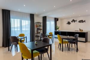 a dining room with tables and yellow chairs at Villa Fortis B&B in Trogir