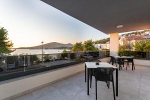 a balcony with tables and chairs and a view of the water at Villa Fortis B&B in Trogir
