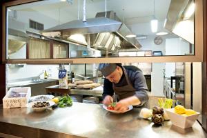 a chef preparing food in a large kitchen at Hotel Mirage in Viareggio +37 photos