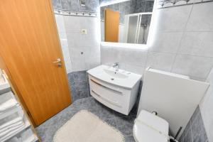 a bathroom with a sink and a toilet and a mirror at White Hill Apartment in Zadar +34 photos