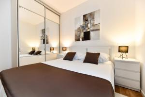 a bedroom with a large white bed and mirrors at White Hill Apartment in Zadar