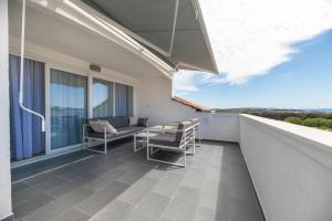 a balcony with a table and chairs on a building at White Hill Apartment in Zadar