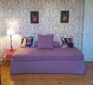 a purple bed in a room with a wall at Chateau de Hiéville in Hiéville