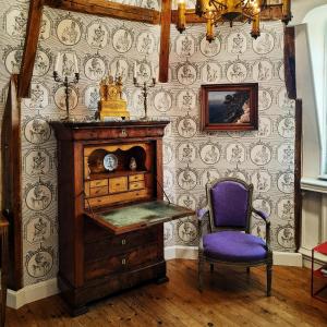 a room with a wooden cabinet and a purple chair at Chateau de Hiéville in Hiéville