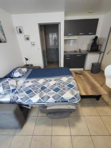 a bedroom with a bed with a blue and white at Studio 2 personnes en centre ville in Saint-Pierre-de-Plesguen