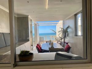 a living room with a table and a view of the ocean at Sea View Penthouse in Ballito