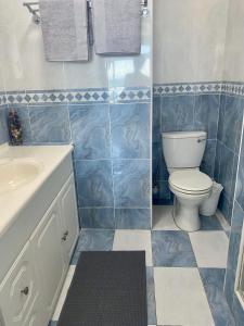a blue tiled bathroom with a toilet and a sink at Sea View Penthouse in Ballito +30 photos