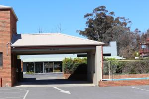 a brick building with a gate and a garage at Bendigo Haymarket Motor Inn in Bendigo