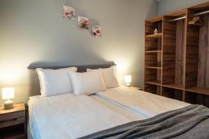 a bedroom with a bed with white sheets and two lamps at Апартаменти 22 in Velingrad +3 photos