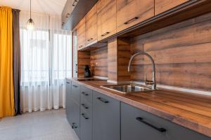 een keuken met een wastafel en een houten muur bij Апартаменти 22 in Velingrad