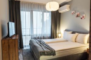 a bedroom with a bed with a large window at Апартаменти 22 in Velingrad