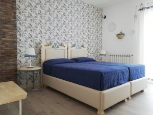 a bedroom with a bed with a blue comforter at Etna Casa del Sole in Nicolosi