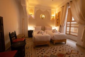 een slaapkamer met 2 bedden en een raam bij Riad El Habib in Marrakesh