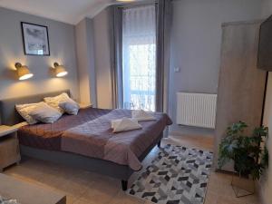 sypialnia z łóżkiem i oknem w obiekcie GRAND VILLA USTKA- Marmonoli w Ustce