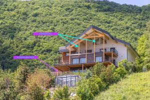 una casa al lado de una colina con descripciones de sus propiedades en Le Panoramic - Loft & Mainfloor Outstanding lake View - LLA Selections by Location lac Annecy, en Sévrier