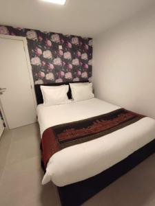 a bedroom with a large bed with a floral headboard at Studio de Spa in Spa