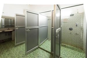 a bathroom with two stalls with a shower at Zizina Otis Resort in Guwahati +25 photos