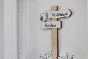 a wooden cross with direction signs on a wall at Idyllic Cottage near Padstow in Little Petherick +29 photos