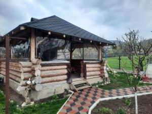 a log cabin with a black roof and a checkered floor at Casa Andreia in Gura Humorului