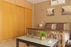 um quarto com uma cama, uma mesa e uma cama em Estudio GardenMar Cabanas Gardens by Your Home Algarve em Cabanas de Tavira