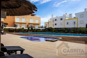 una piscina di fronte ad alcuni edifici di Estudio GardenMar Cabanas Gardens by Your Home Algarve a Cabanas de Tavira