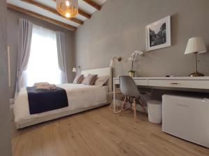 una camera da letto con un letto, una scrivania e una finestra di Manno Rooms Affittacamere a Cagliari