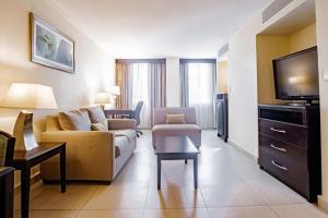 a living room with a couch and a tv at Studio Coliving Hotel in Panama City