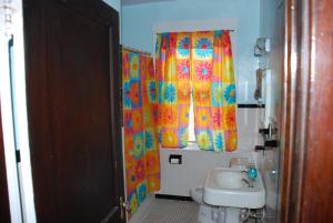 a bathroom with a shower curtain and a sink at Old Time Beach Front Cottage - The Beach is your Backyard! Pet Friendly cottage in North Camellia Acres +28 photos