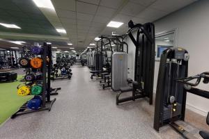 a gym with many rows of treadms and machines at Village Hotel Maidstone in Maidstone