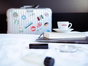 una taza de café sentada en una mesa con un libro en aletto Hotel Kudamm en Berlín