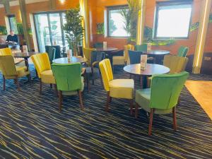 a restaurant with tables and chairs in a room at Boston West Hotel in Boston