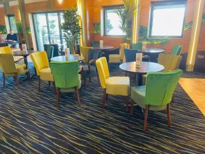 - un restaurant avec des tables et des chaises dans une salle dans l'établissement Boston West Hotel, à Boston