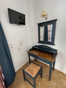 a dressing table with a mirror and a stool at Leonidas Apartments in Kamari