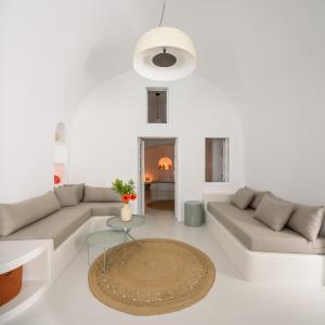 a living room with a couch and a table at Lathouri Cave Villa in Oia