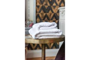 a stack of towels on a stool in front of a mirror at City Centre All In One Apartment by BookingHost in Warsaw +23 photos