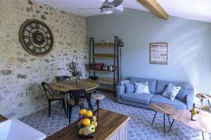 ein Wohnzimmer mit einem blauen Sofa und einem Tisch in der Unterkunft Cottage - La Maison du Château - By DOMAINE RIBERACH in Bélesta + 35 Fotos