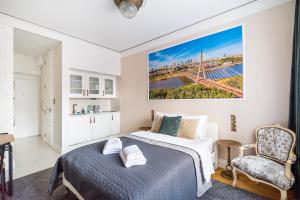 a bedroom with a bed and a chair at City Centre All In One Apartment by BookingHost in Warsaw