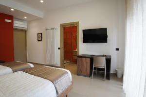 a bedroom with a bed and a desk with a television at Villa Mafalda B&B in Frattamaggiore +18 photos