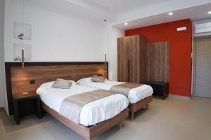 a bedroom with two beds and a red wall at Villa Mafalda B&B in Frattamaggiore
