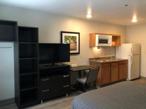 a room with a bedroom with a desk and a kitchen at WoodSpring Suites Charlotte Gastonia in Gastonia