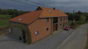 a house with a red car parked next to a street at Appartement Duplex Au Chat'rme des Blanches Pierres in Francorchamps