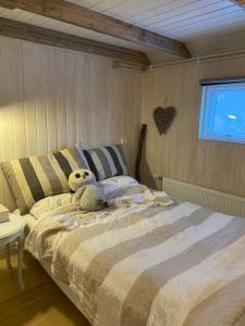 - une chambre avec un lit avec un animal rembourré dans l'établissement A three bedroom cabin with a hot tub, à Selfoss