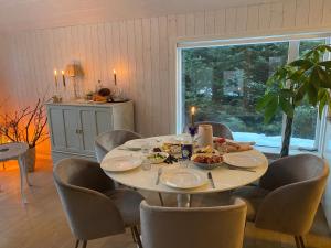 un comedor con mesa y sillas con comida. en A three bedroom cabin with a hot tub, en Selfoss