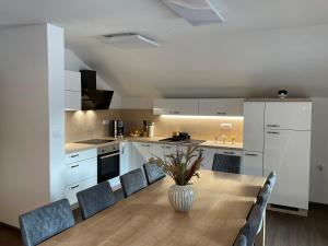 a kitchen with a table with chairs and a vase on it at Apartmaji ENIA Rateče-Planica, Kranjska Gora in Kranjska Gora